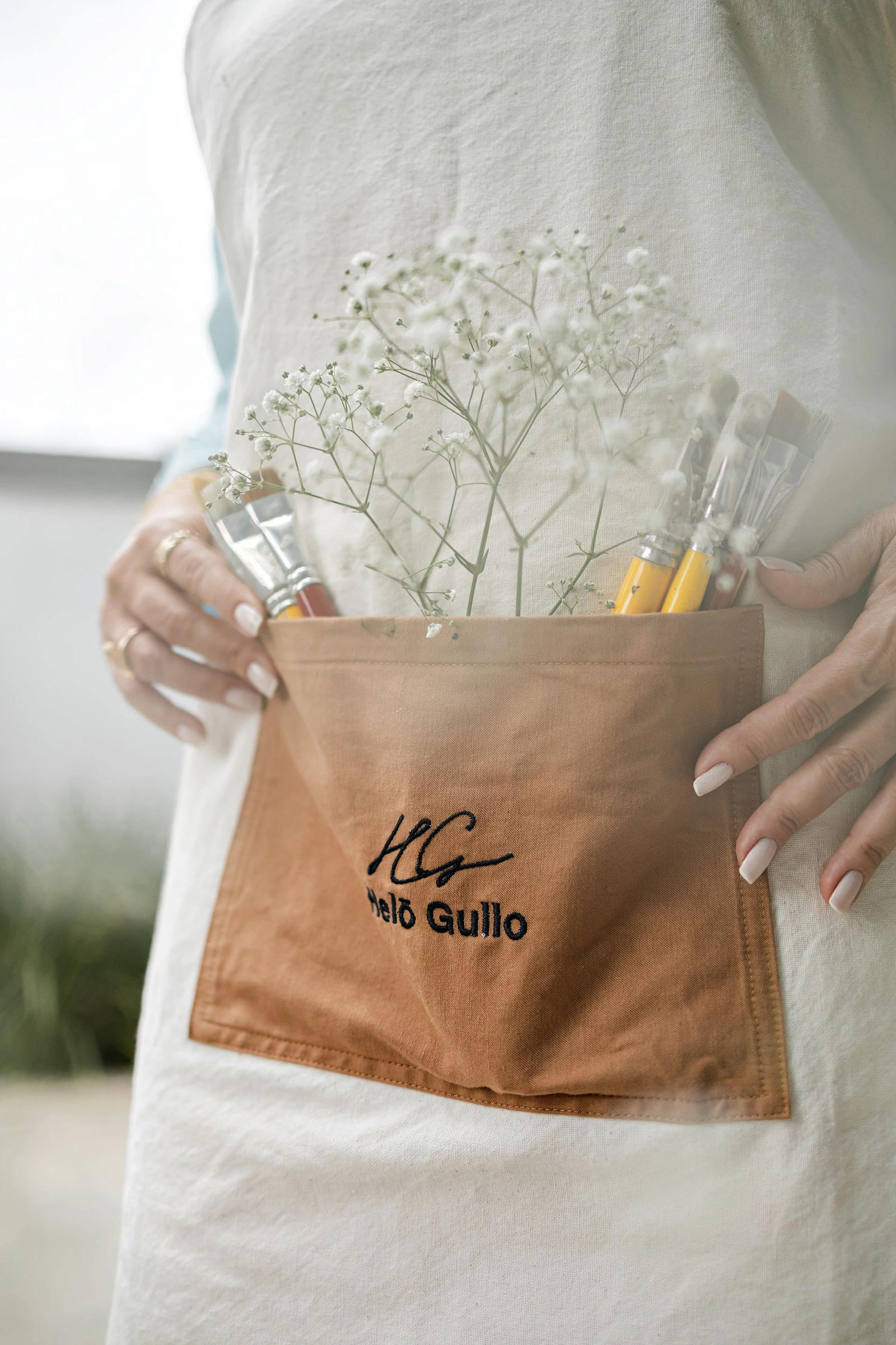 Avental Helô Gullo com pincéis e flores